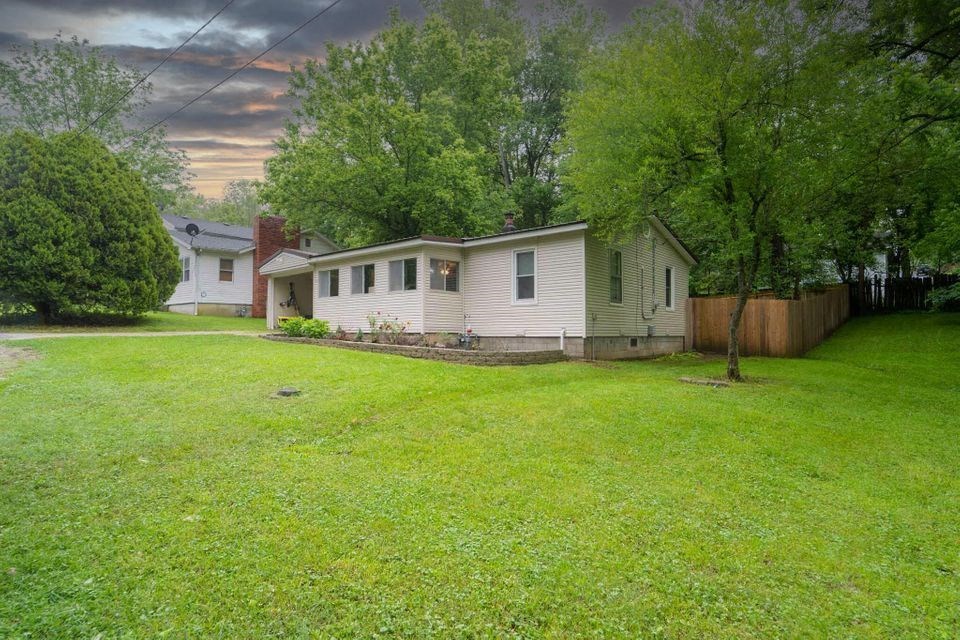 a white house with a yard and a tree