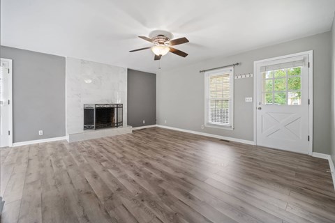 A spacious living room with a fireplace and hardwood floors.