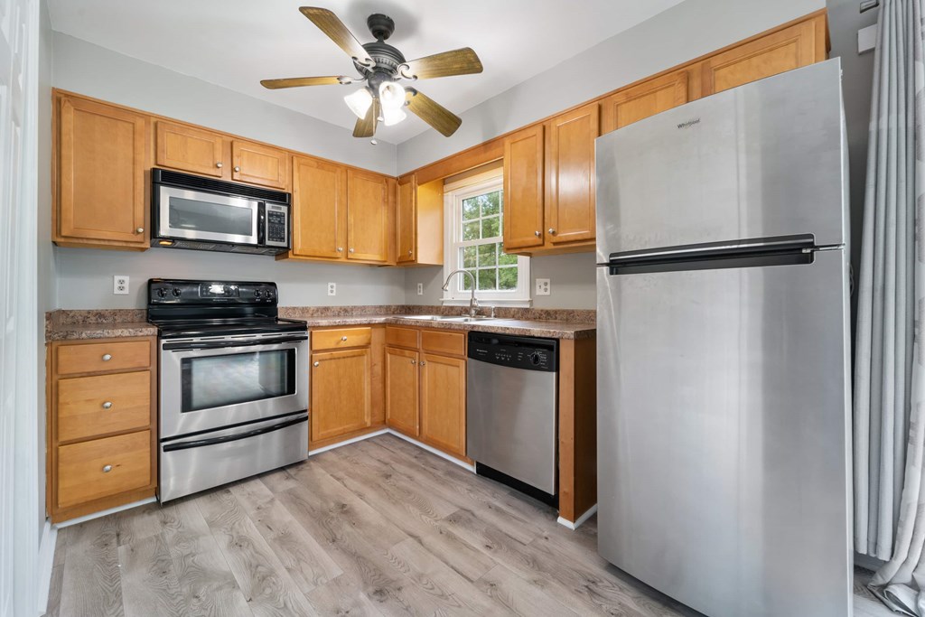 A kitchen with wooden cabinets and stainless steel appliances.