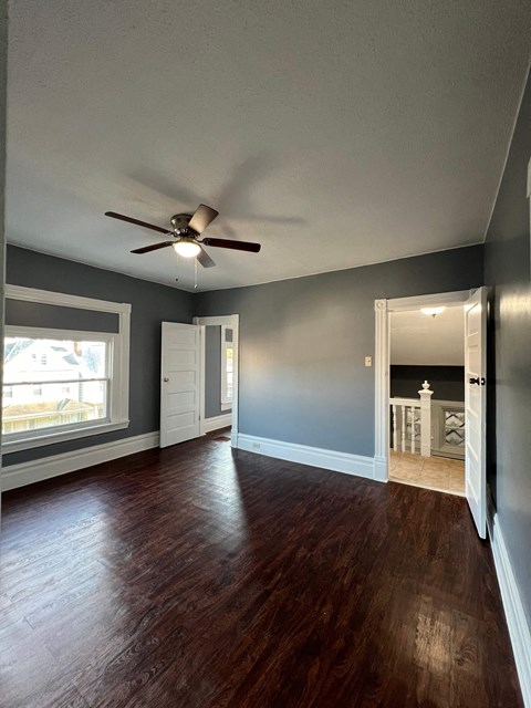 a living room with blue walls and a ceiling fan