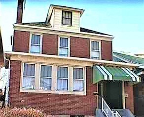 an old brick house with a green and white awning