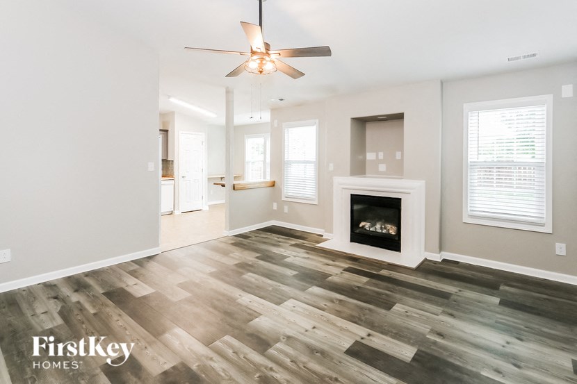 a living room with a fireplace and a ceiling fan