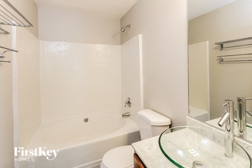 a white bathroom with a tub and a toilet and a sink