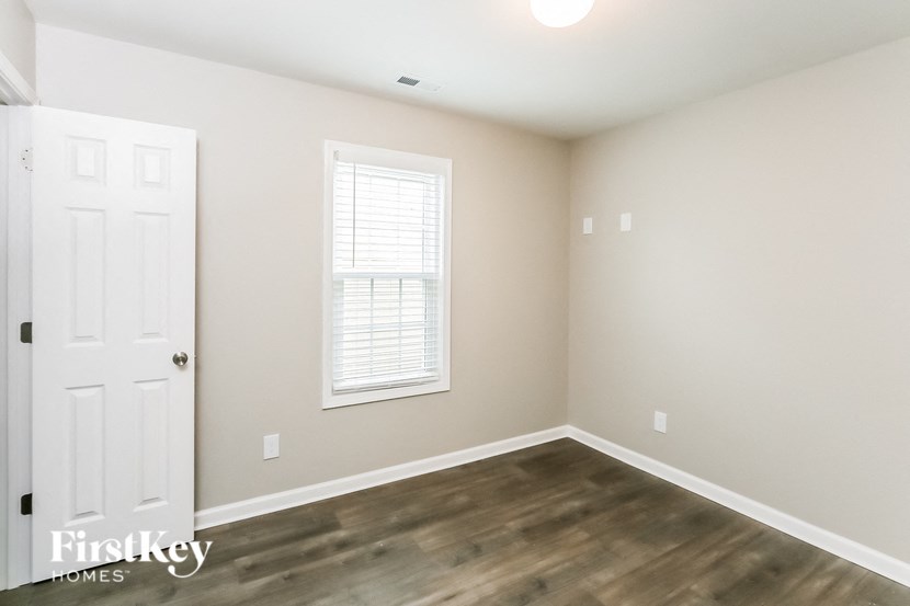 the living room of a home with a white door and a window