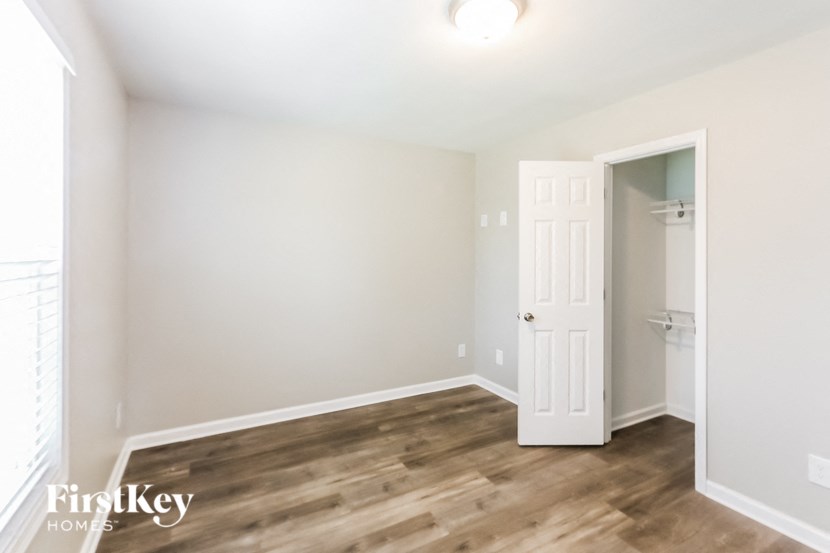 an empty room with a white door and a closet