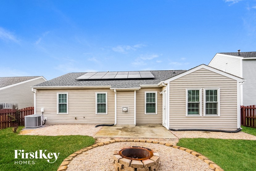 a backyard with a fire pit and a house with solar panels