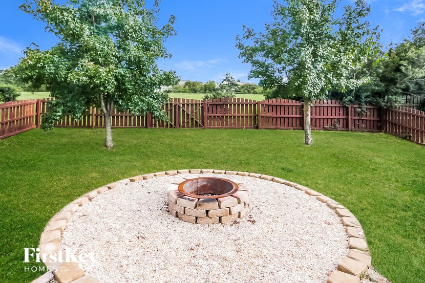 a backyard with a fire pit and a fence