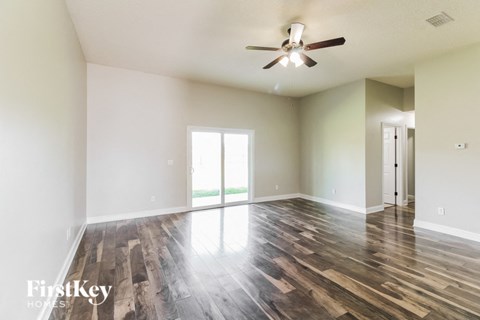 A room with wooden flooring and a ceiling fan.