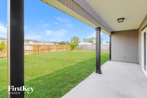 A patio area with a view of a fence and trees.