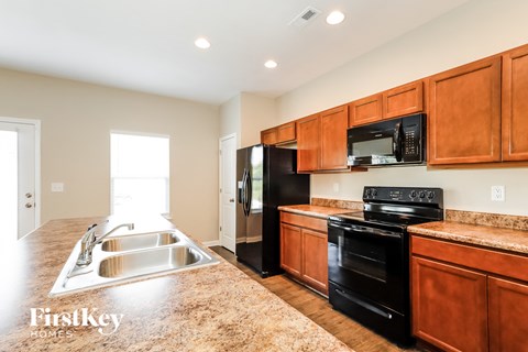 a kitchen with black appliances and wooden cabinets and granite counter tops