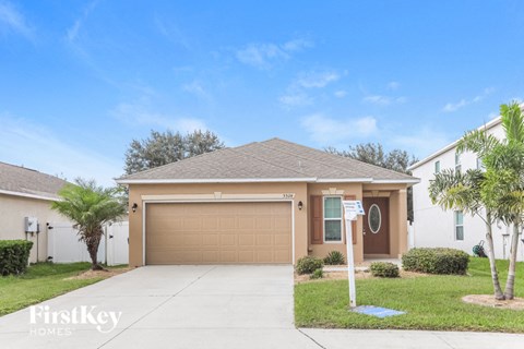 a home with a garage door and a palm tree