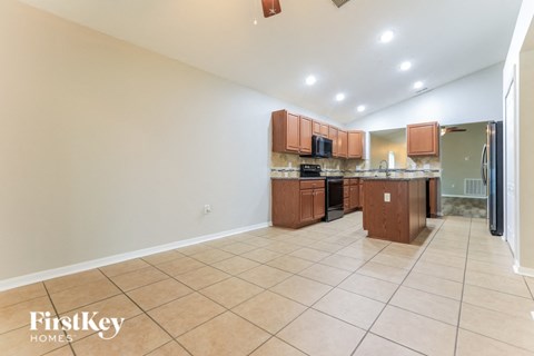 a large kitchen with a large tiled floor and wooden cabinets