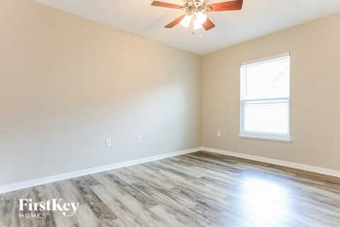 a living room with wood floors and a ceiling fan