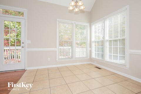 A room with a door and a window with blinds.