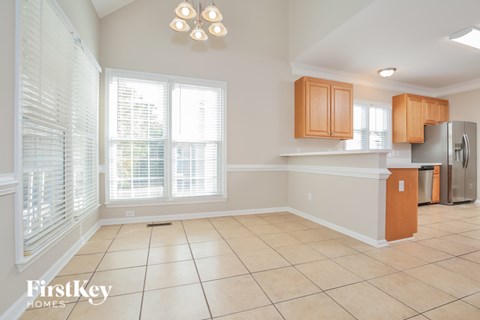 A kitchen with wooden cabinets and a tile floor.