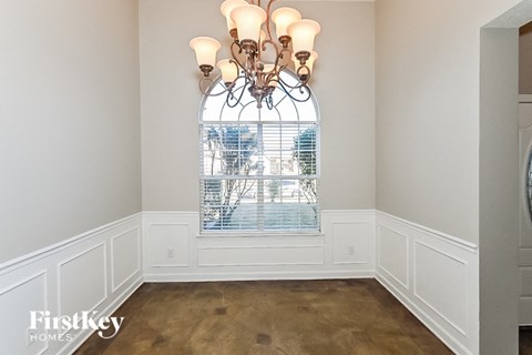 a dining room with a large window and a chandelier