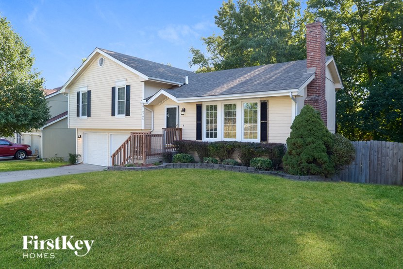 A house with a red car parked in front.