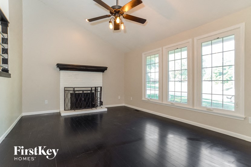 A room with a fireplace and a ceiling fan.