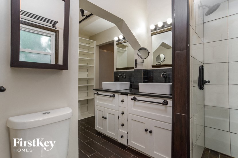 A bathroom with a tub, sink, and mirror.