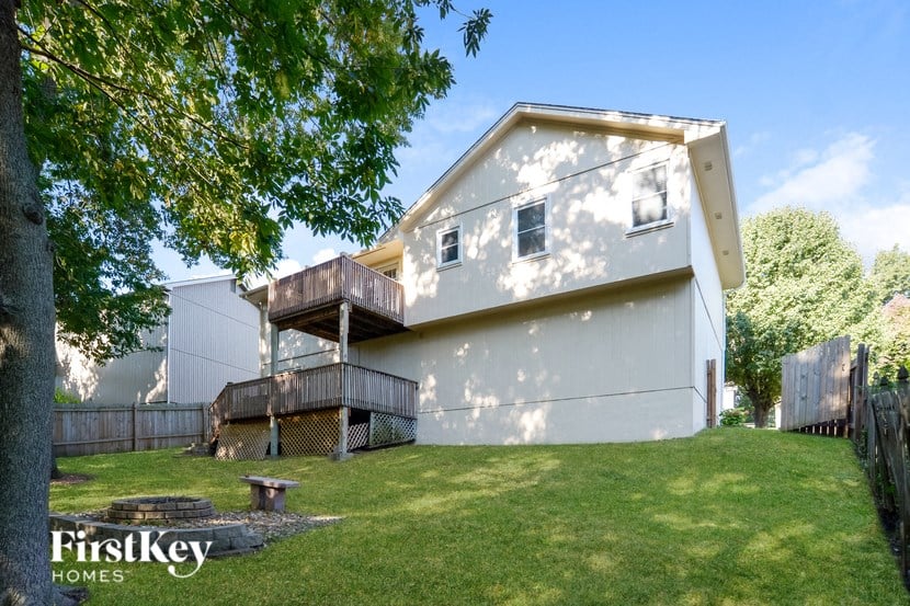 A house with a white exterior and a balcony is shown.