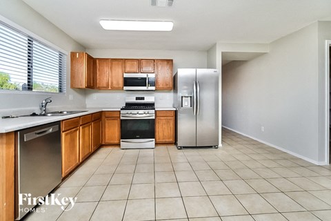 A kitchen with wooden cabinets and a refrigerator.