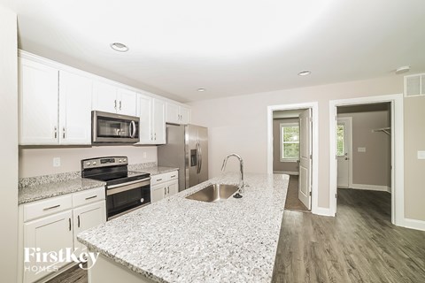 A kitchen with granite countertops and stainless steel appliances.