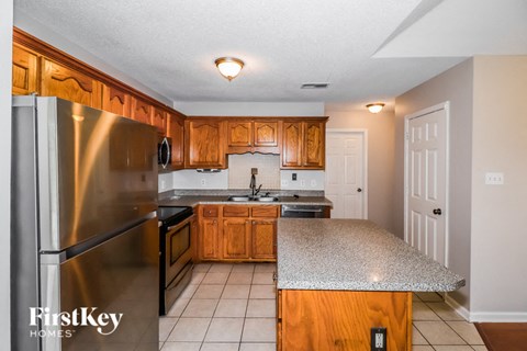 A kitchen with wooden cabinets and a stainless steel refrigerator.