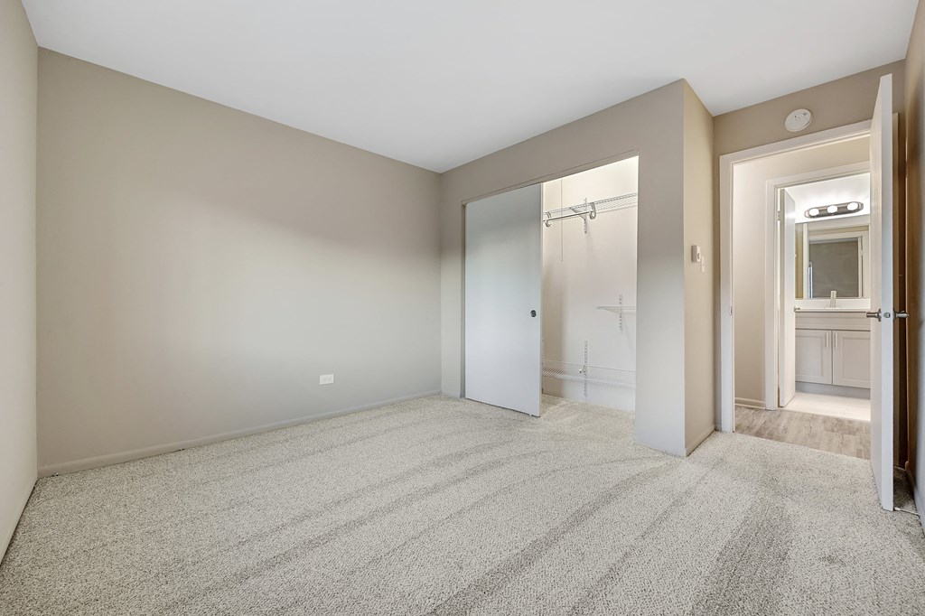 an empty living room with a closet and a bathroom