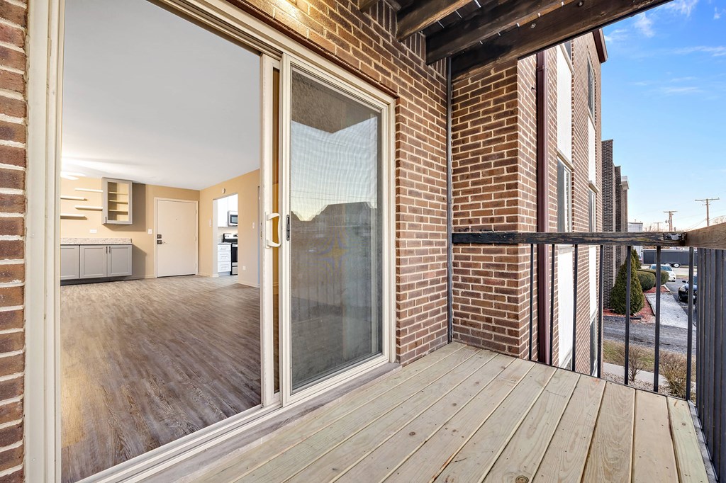 a sliding glass door on a balcony in a brick building