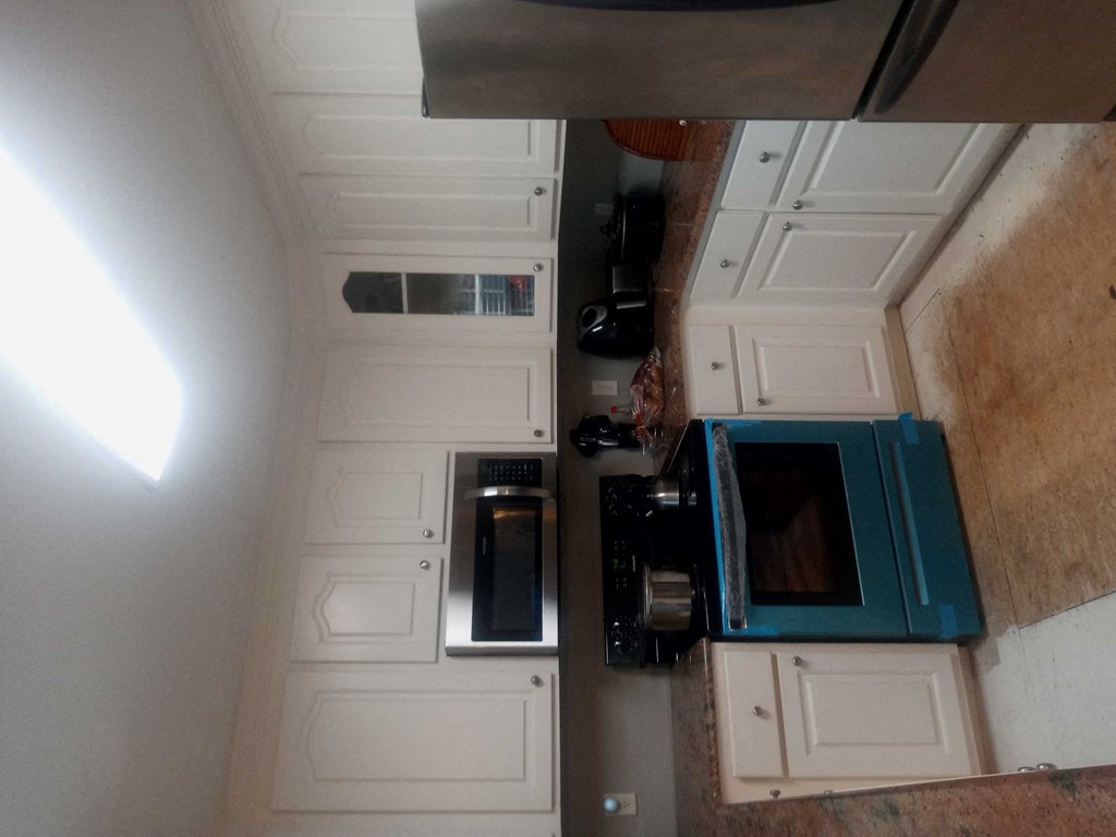 A kitchen with a microwave, oven, and toaster.