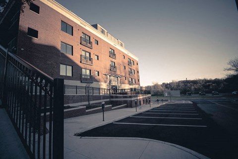 A red brick building with a parking lot in front.