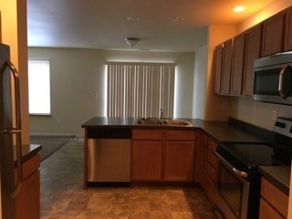 A kitchen with wooden cabinets and a black countertop.