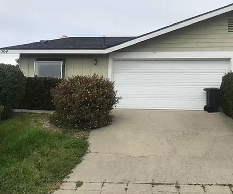 A house with a garage door and a driveway.