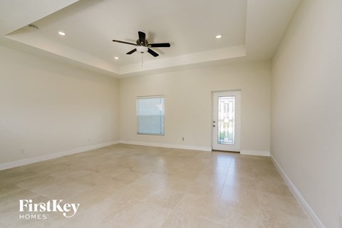 an empty living room with a ceiling fan