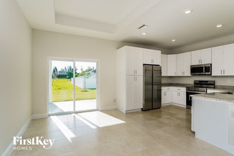 a large kitchen with white cabinets and stainless steel appliances