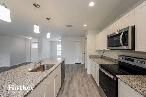 renovated kitchen with granite counter tops and stainless steel appliances and white cabinets