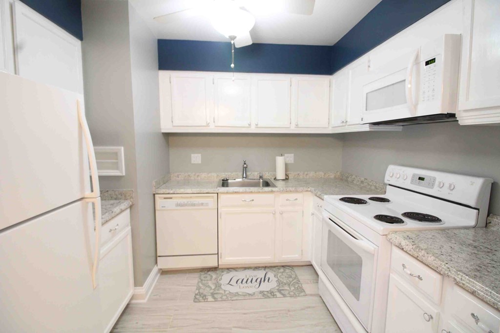 a kitchen with white appliances and white cabinets