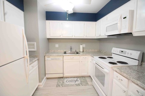a kitchen with white appliances and white cabinets