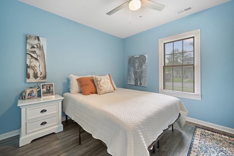 A bedroom with a white bed and a blue wall.