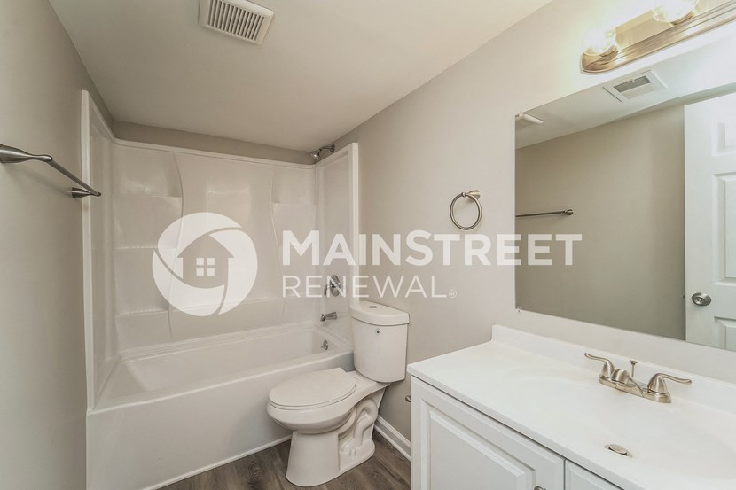 a bathroom with a toilet and a sink and a bath tub