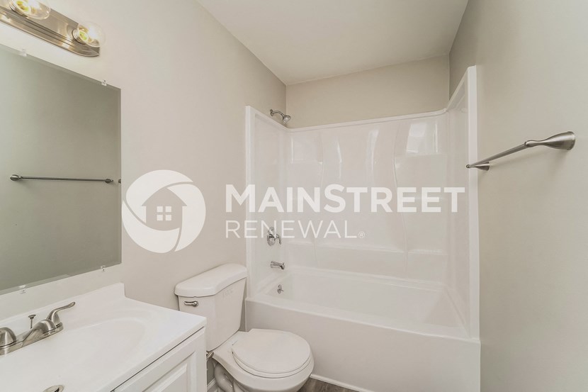 a renovated bathroom with white fixtures and a white toilet and sink