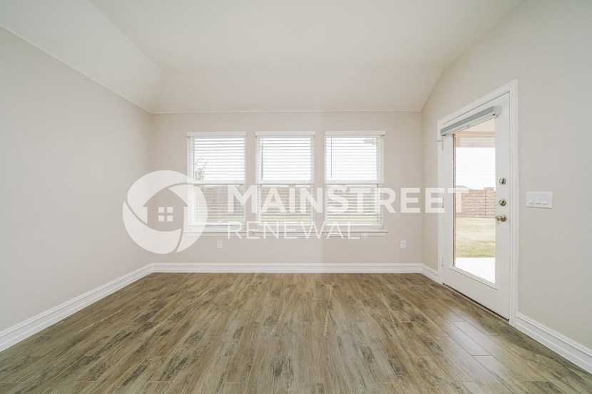 renovated living room with hardwood flooring and exit to the backyard