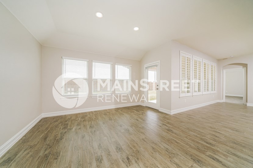 a renovated living room with hardwood floors and white walls