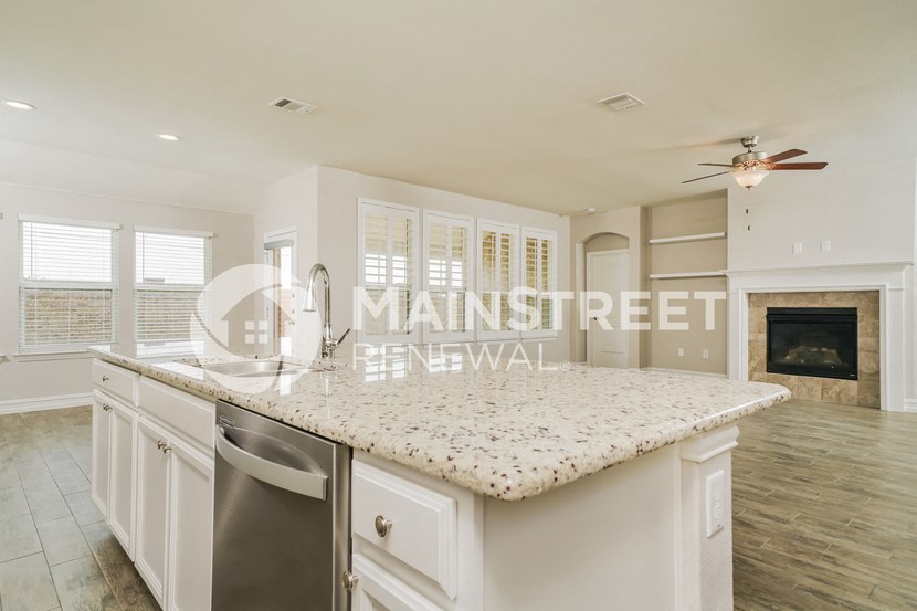 a kitchen with a marble counter top and a fireplace