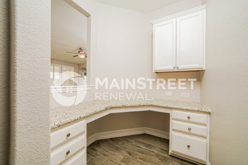 a kitchen with white cabinets and a counter top