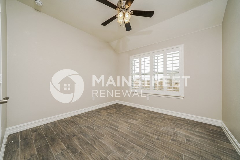 a living room with a ceiling fan and a window