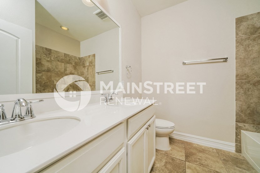 a bathroom with a sink and a toilet and a mirror