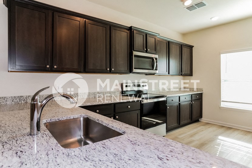 a kitchen with granite counter tops and black cabinets