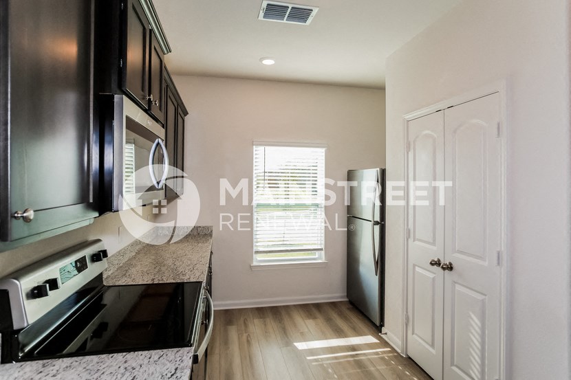 a renovated kitchen with white cabinets and stainless steel appliances