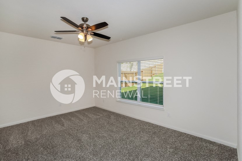 a bedroom with a ceiling fan and a window